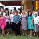 Group of people smiling and posing together outside a building during a community event.