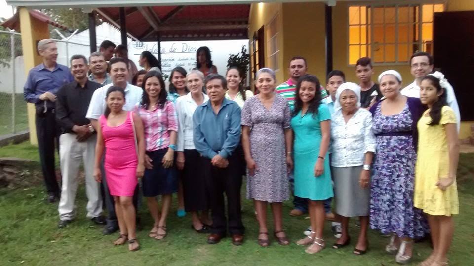 Group of people smiling and posing together outside a building during a community event.