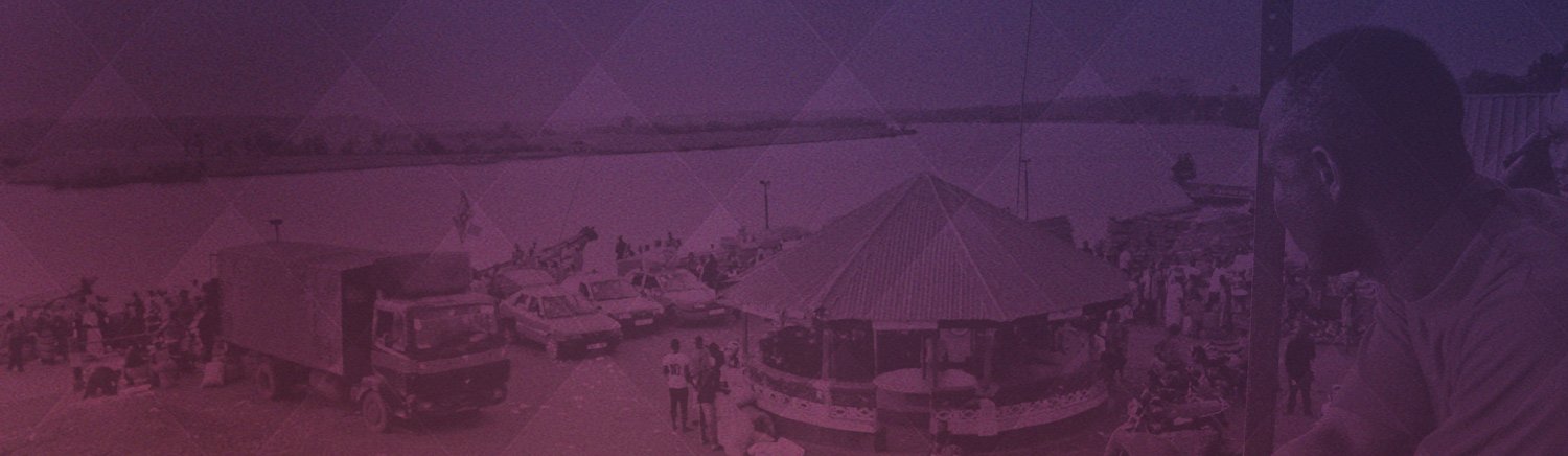 Scenic riverside with gathering, vehicles, and structures under a gradient filter, person observing the busy scene.
