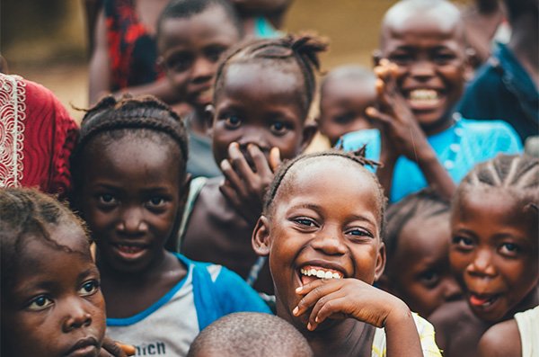 Joyful group of children smiling and laughing together outdoors.