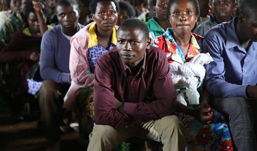 A group of people sitting together, attentively listening in a crowded room.